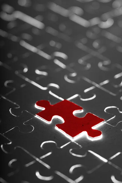 Black puzzle with one red piece — Stock Photo, Image