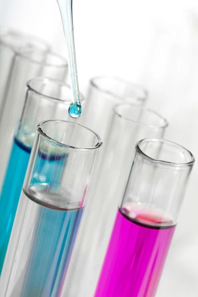 Liquid dripping from pipette into test tube — Stock Photo, Image