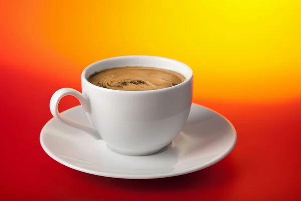 Cup of coffee over red and yellow background — Stok fotoğraf