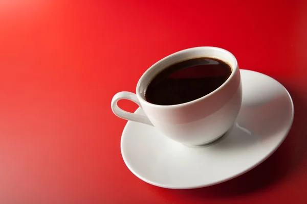 Kopp kaffe över röd bakgrund — Stockfoto