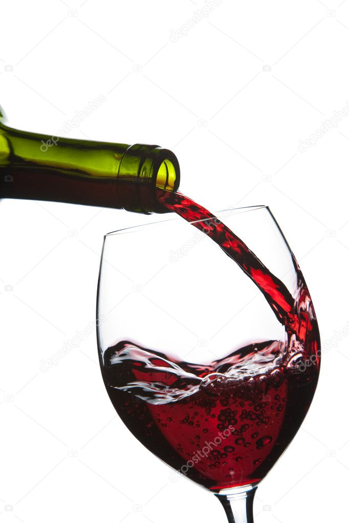 Red wine pouring into glass isolated