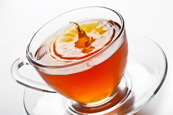 Salpicadura de té en taza de vidrio — Foto de Stock
