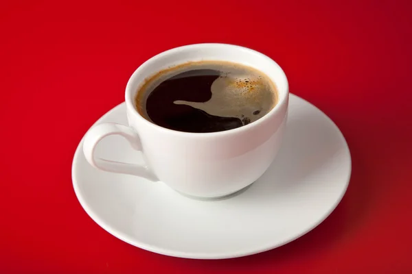 Šálek kávy na červeném pozadí — Stock fotografie