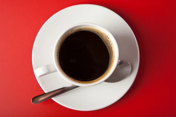 Kopje koffie op rode achtergrond — Stockfoto