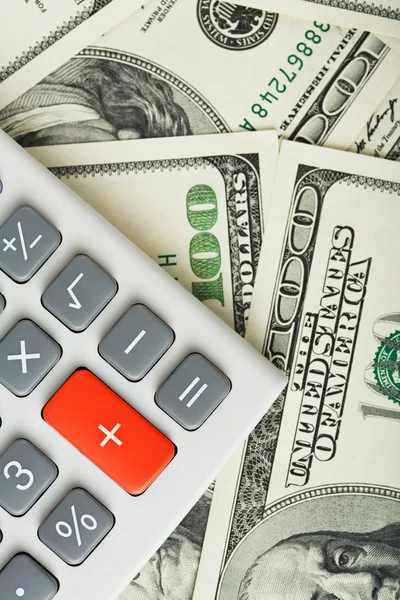 Доллары и калькулятор с красной кнопкой — стоковое фото