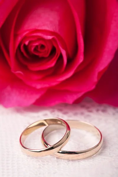金の結婚指輪とピンクのバラ — ストック写真