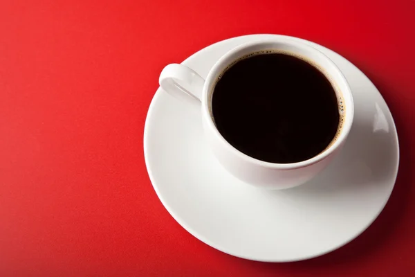 Kopje koffie op rode achtergrond — Stockfoto