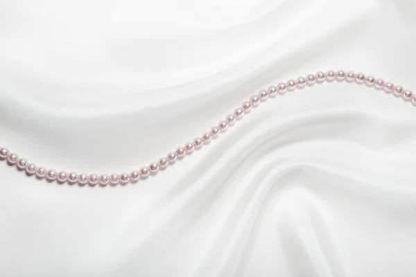 Жемчужное ожерелье над белым шелком — стоковое фото