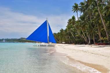 Traditional paraw sailing boat on white beach on boracay island clipart
