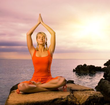 Beautiful young woman doing yoga exercise outdoors clipart