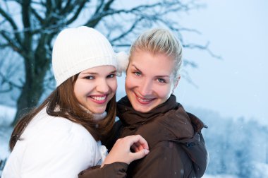 Two beautiful women in winter clothing outdoors clipart