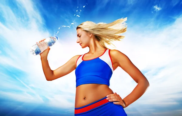 Молода жінка п'є воду після фізичних вправ — стокове фото