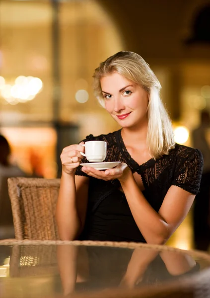 Krásná mladá žena pít kávu v restauraci — Stock fotografie
