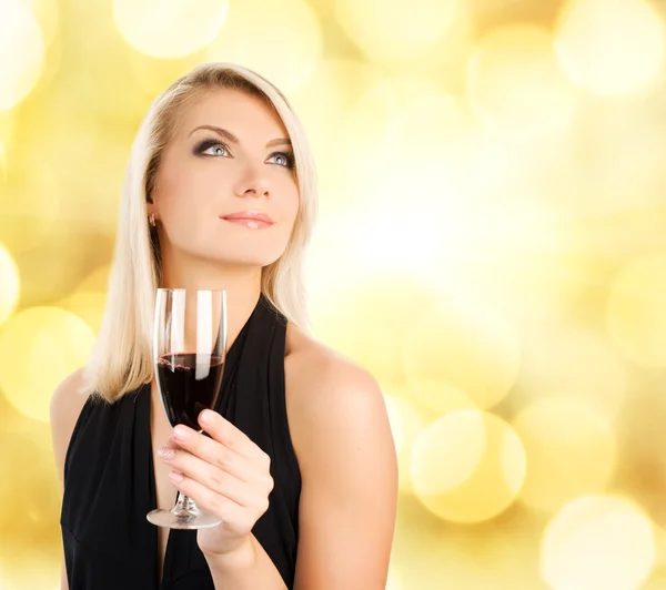 Krásná mladá žena se sklenkou vína přes abstraktní rozmazané — Stock fotografie