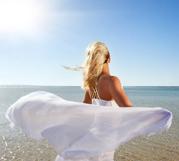 Femme blonde avec châle blanc relaxant près de la mer — Photo