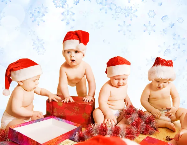 Gruppo di adorabili bambini in cappelli di Natale confezionamento regali — Foto Stock
