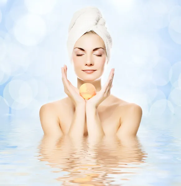 Aroma banyo topu ile güzel bir genç kadın suya yansıyan — Stok fotoğraf
