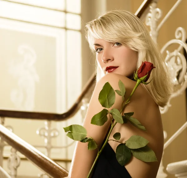 Όμορφη νεαρή γυναίκα με ένα κόκκινο τριαντάφυλλο — Φωτογραφία Αρχείου