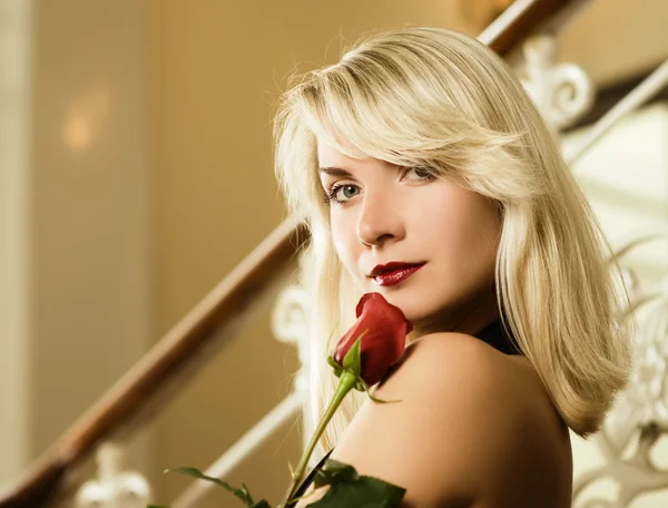 Красивая молодая женщина с красной розой — стоковое фото
