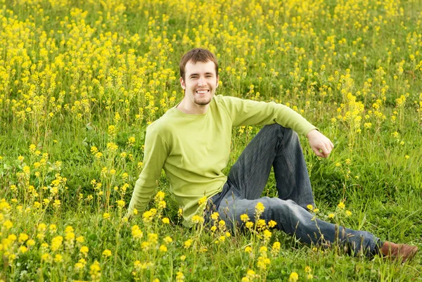 Spokojny Młody Człowiek Siedzi Polu Kwiat — Zdjęcie stockowe