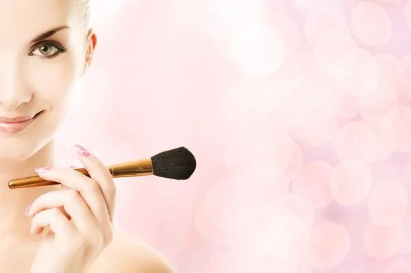 Schöne junge Frau mit einem Make-up-Pinsel — Stockfoto