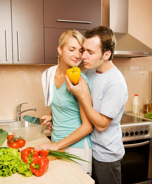 Молодая пара делает овощной салат на кухне — стоковое фото