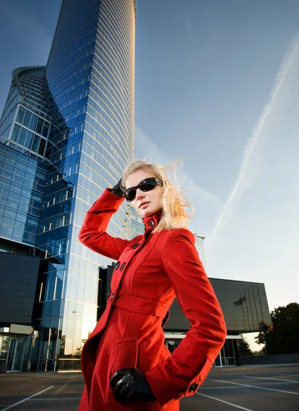 Schöne junge blonde Frau im Freien. Modernes Gebäude hinter ihr — Stockfoto