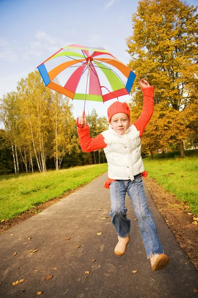 Beautiful little girl with umbrella in a forest — Stock Photo, Image