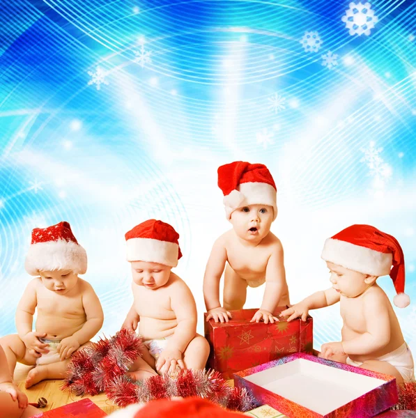 Grupa urocze Berbecie w Boże Narodzenie hats pakowania prezentów — Zdjęcie stockowe