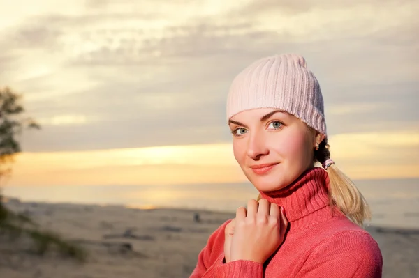 Ung kvinna på en strand i solnedgången. närbild porträtt — Stockfoto