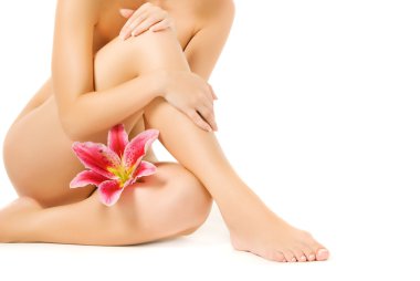Female legs with pink lily isolated on white background clipart