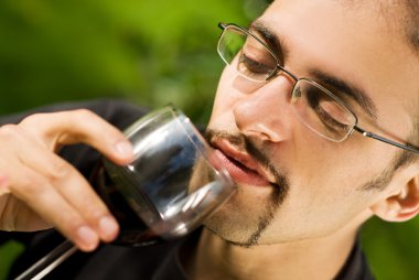 Handsome young man drinking red wine clipart