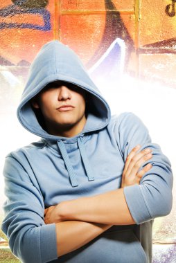 Cool looking man in a hood over abstract graffity background clipart