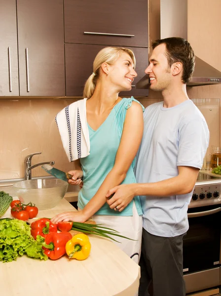 若いカップルは台所で野菜サラダを作る — ストック写真
