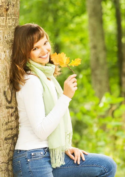 Hermosa morena romántica con hoja de otoño dorado primer plano por —  Fotos de Stock