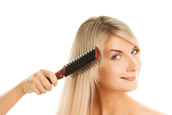 Mulher bonita penteando seu cabelo — Fotografia de Stock