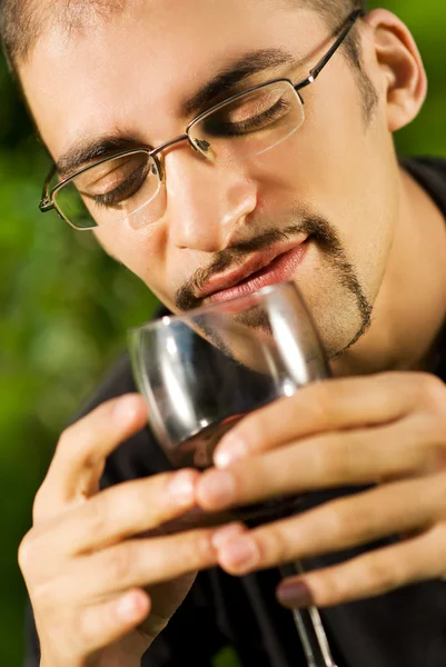 Bonito jovem bebendo vinho tinto — Fotografia de Stock