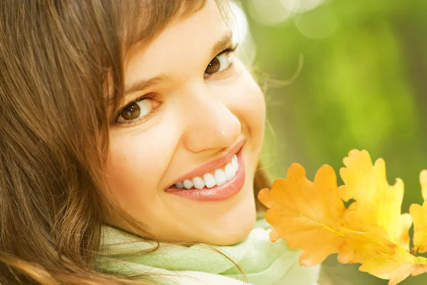 Hermosa morena romántica con hoja de otoño dorado primer plano por — Foto de Stock