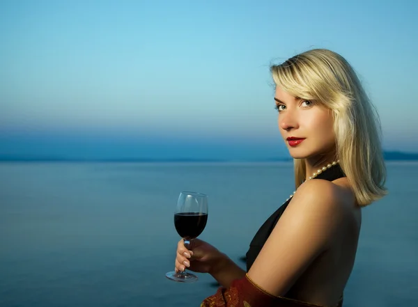 美丽的年轻女子在海边喝红酒 — 图库照片