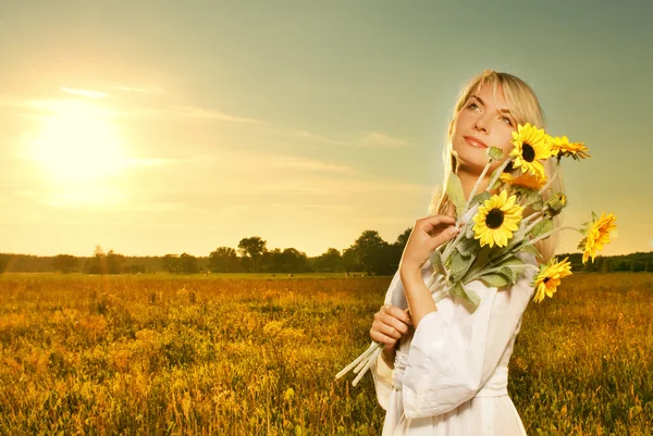 Młoda piękna kobieta z bukietem słoneczników w polu — Zdjęcie stockowe