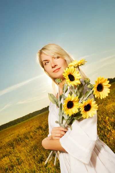 Young beautiful woman with a bouquet of sunflowers in the field — Stock Photo, Image