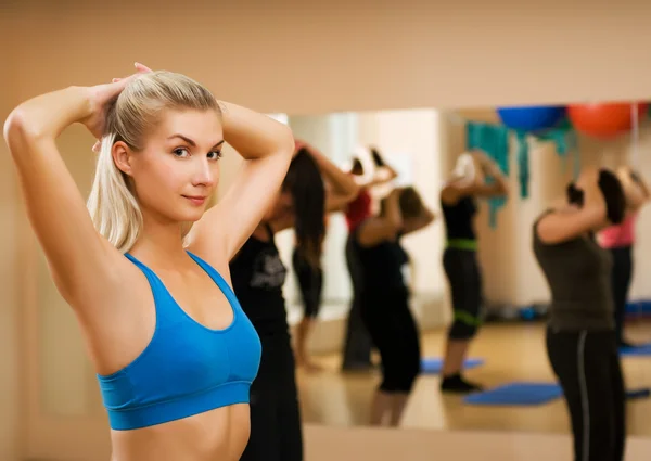 Mooie jonge vrouw doen fitness oefening in een sportclub — Stockfoto
