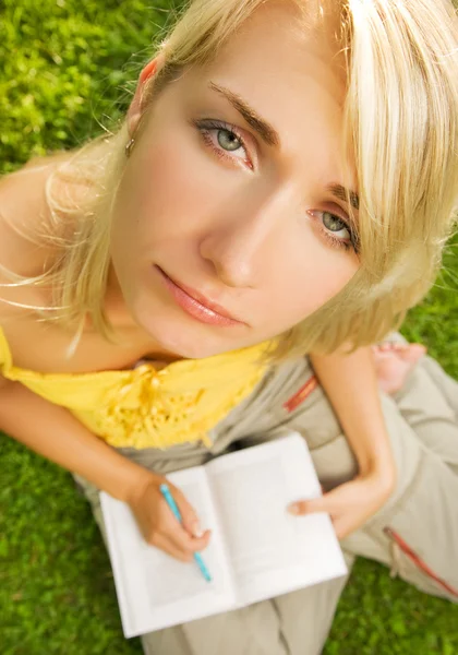 悲伤的年轻女孩 坐在草和阅读的书上的 Oudoors — 图库照片