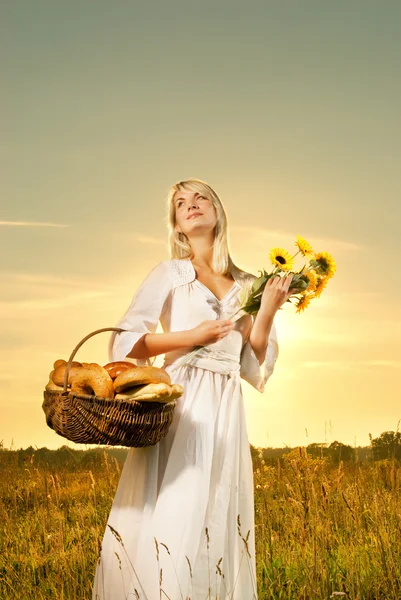 Красива молода жінка з кошиком, повним свіжого запеченого хліба — стокове фото