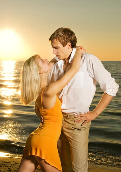 Młoda para w miłości, w pobliżu oceanu na zachodzie słońca — Zdjęcie stockowe