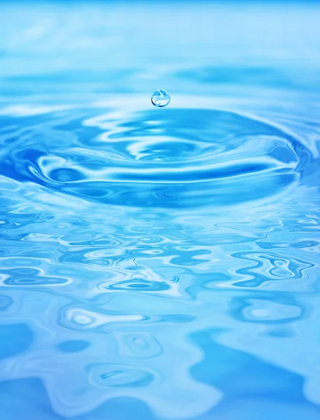 Gotas caindo na água azul — Fotografia de Stock