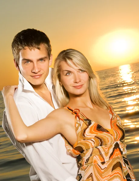 Młoda para w miłości, w pobliżu oceanu na zachodzie słońca — Zdjęcie stockowe