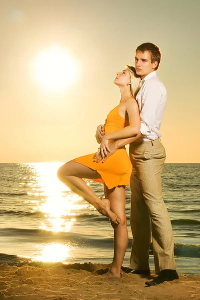 愛の若いカップルの日没で海を近く — ストック写真