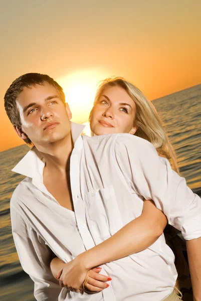 Jong paar in liefde in de buurt van de Oceaan bij zonsondergang — Stockfoto