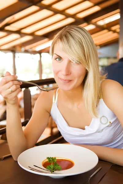 Mladá žena jíst rajskou polévku v restauraci — Stock fotografie